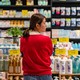 A woman looking overwhelmed by products in a Chinese grocery store.