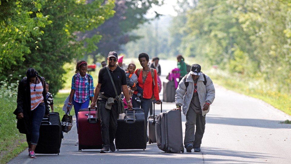 Asylum seekers walk down Roxham Road to cross into Quebec at the U.S.-Canada border in 2017.