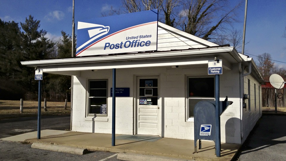 A white building with a United States Post Office sign on a clear day