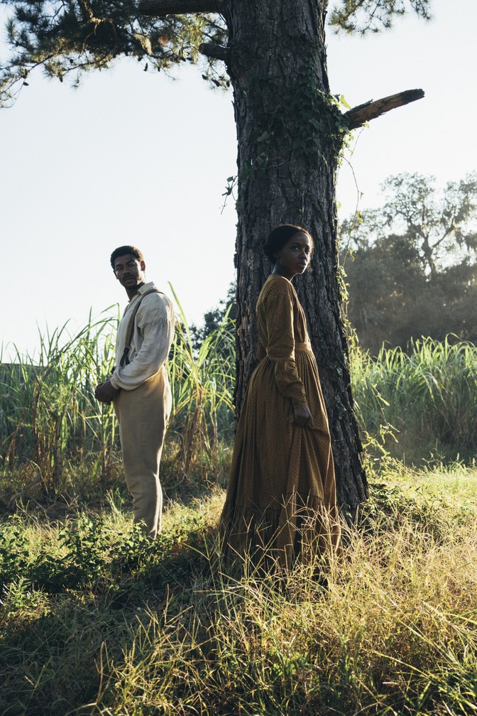 cora and caesar standing by a tree in a scene from 'the underground railroad'