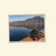 An illustration of a printed photo of a boat rope sitting in front of a body of water and a mountain.