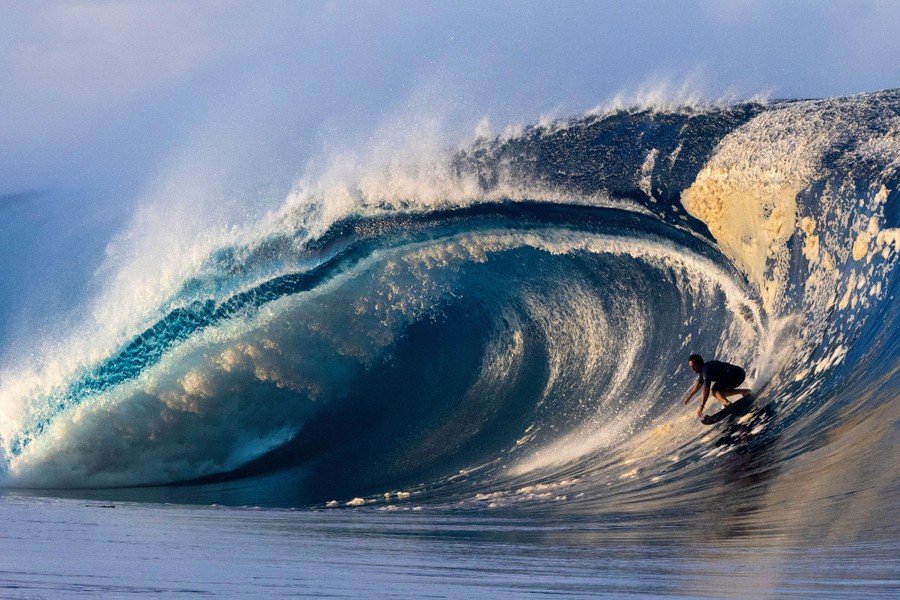 A surfer rides a large wave.