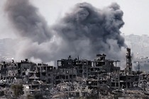 A smoke plume erupts above the Gaza Strip during Israeli bombardment