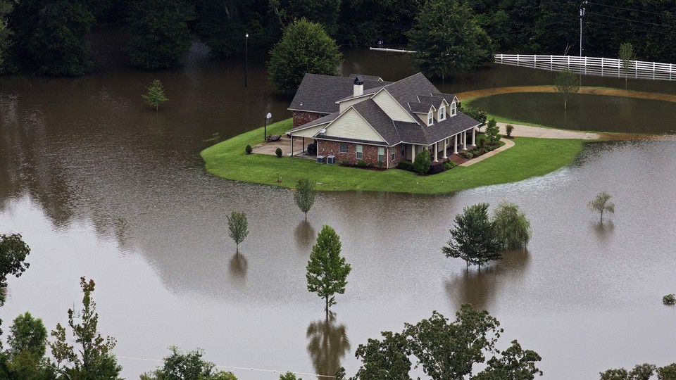 An aerial photo over Amite, Louisiana, shows a home surrounded by water.