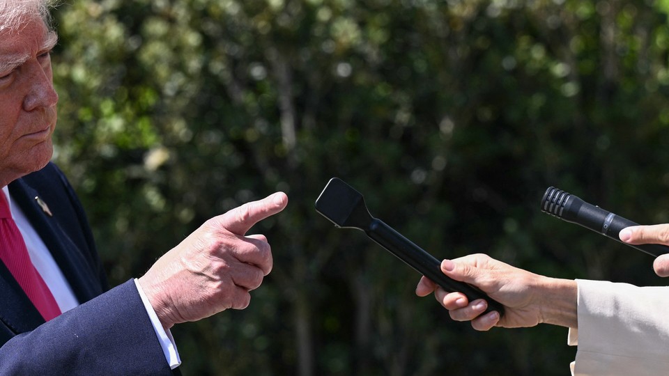Donald Trump pointing his finger at a microphone