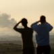 People looking at smoke over the Gaza Strip