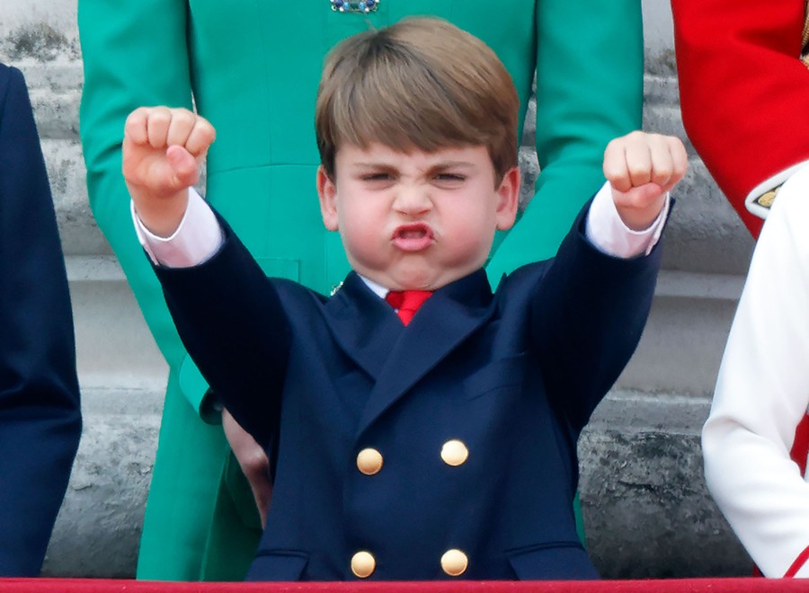 A boy raises his arms and makes a face.