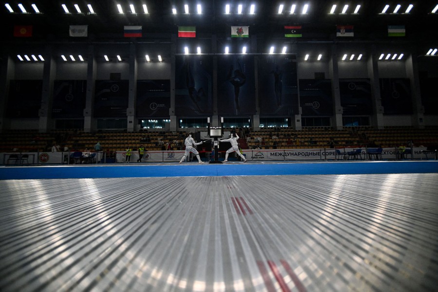 Two people compete in a fencing match.