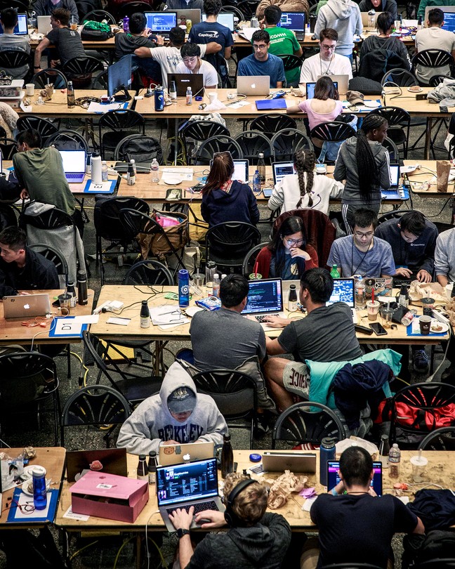 Photo of college students working at their computers as part of a hackathon at Berkeley in 2018