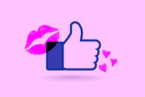 Facebook's "Like" icon surrounded by pink hearts and a pink lipstick mark.