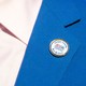 An up-close image of a suit, with a pin that reads "Chagos Islands Are British" on the blue lapel.