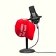 A red “Make America Great Again” cap resting on a podcast microphone