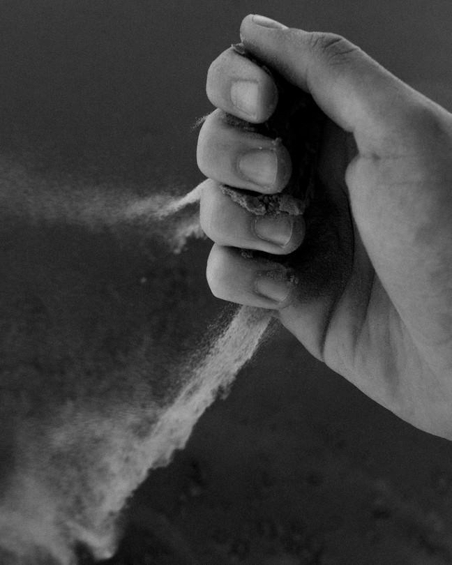 A hand with dust falling through its fingers