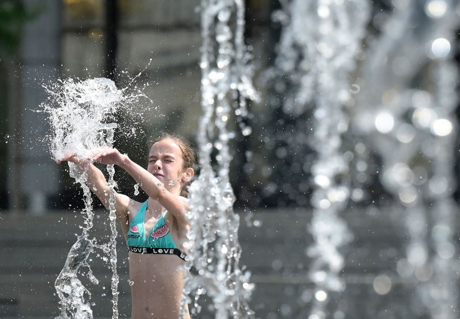 A girl plays in a fountain.