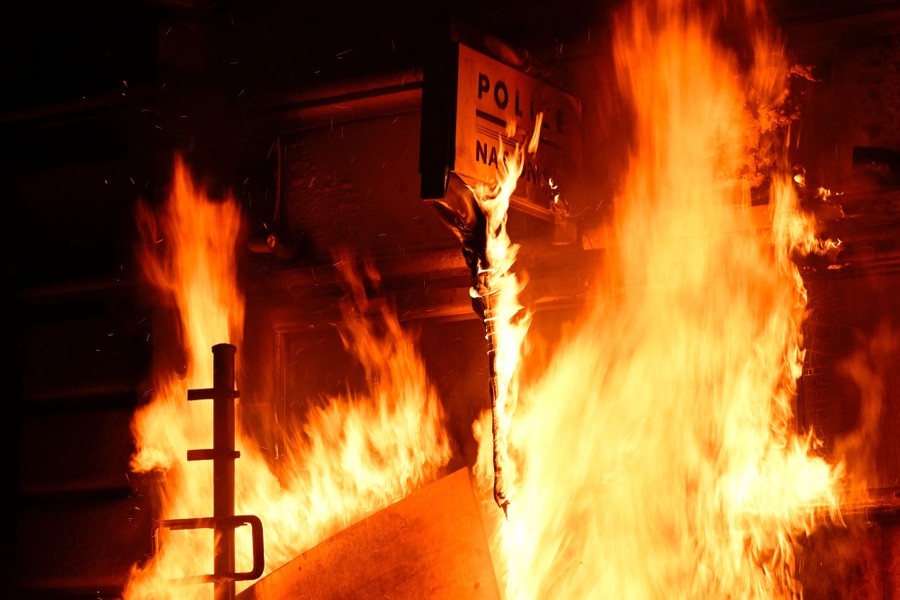 Fire burns on the facade of a police station.