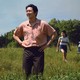 The Yi family stands in a field in front of their car