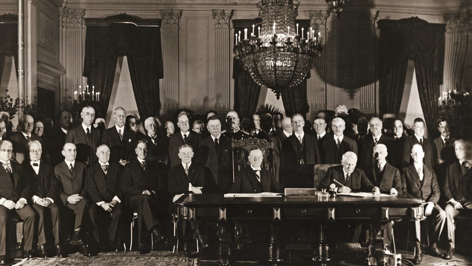 Members of the Cabinet, Senate, and Congress are seen gathered in the East Room of the White House, after President Coolidge and Secretary of State Kellogg signed the Kellogg-Briand Pact.