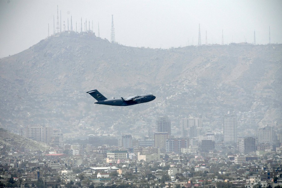 A military transport plane takes off from Kabul, visible in the background.