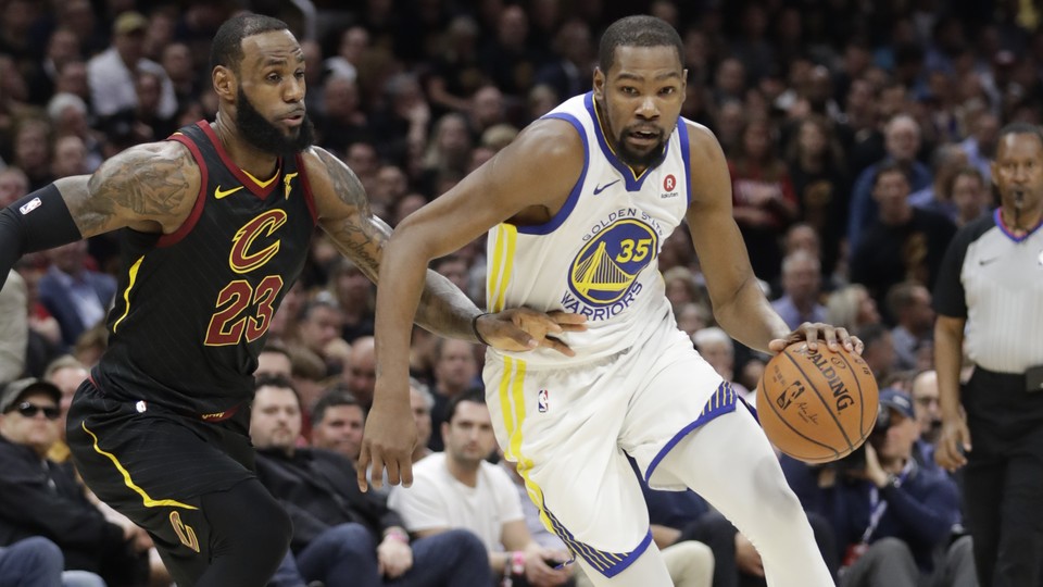 The Golden State Warriors' Kevin Durant goes to the basket against the Cleveland Cavaliers' LeBron James in the first half of Game 4 of basketball's NBA Finals on June 8, 2018, in Cleveland