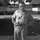 William L. "Atomic Bill" Laurence standing with hands on hips at Tinian Island in the Pacific, the launching point for the atomic bomb attacks against Hiroshima and Nagasaki