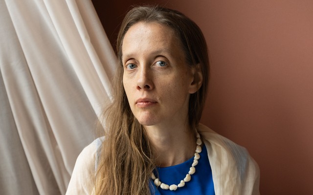 A woman in a blue dress sits at a white table