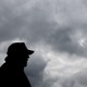 The silhouette of Donald Trump in front of a grey cloudy sky