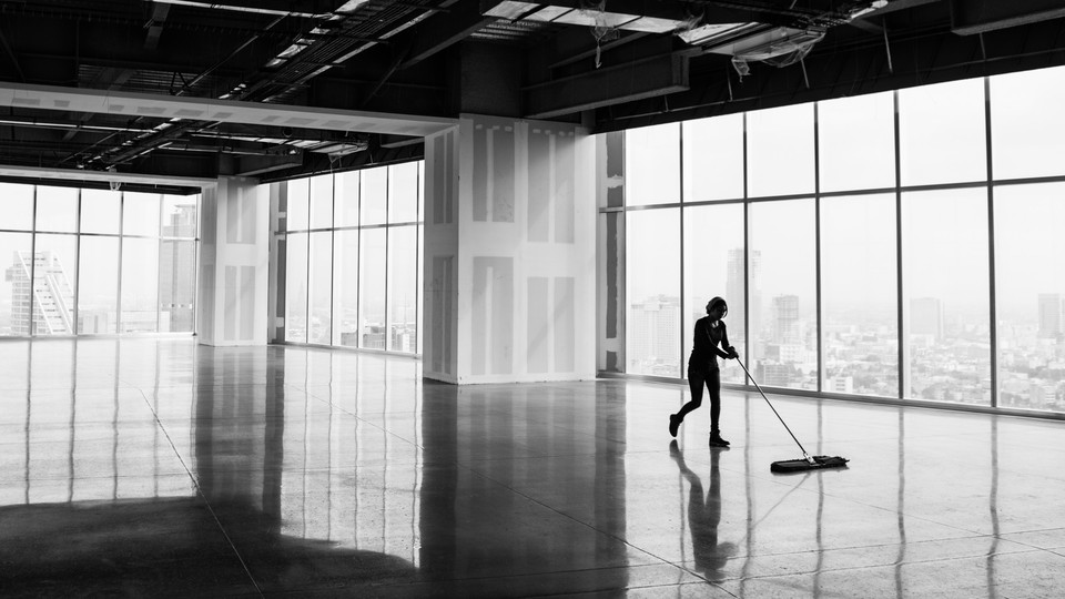A person mopping the floor of an empty building