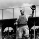 A black-and-white photograph of Moe Berg, catcher, in action