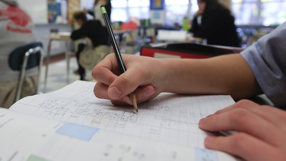 A student does math in a notebook.