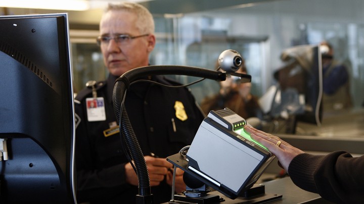A traveler scans their fingerprints at an airport checkpoint.