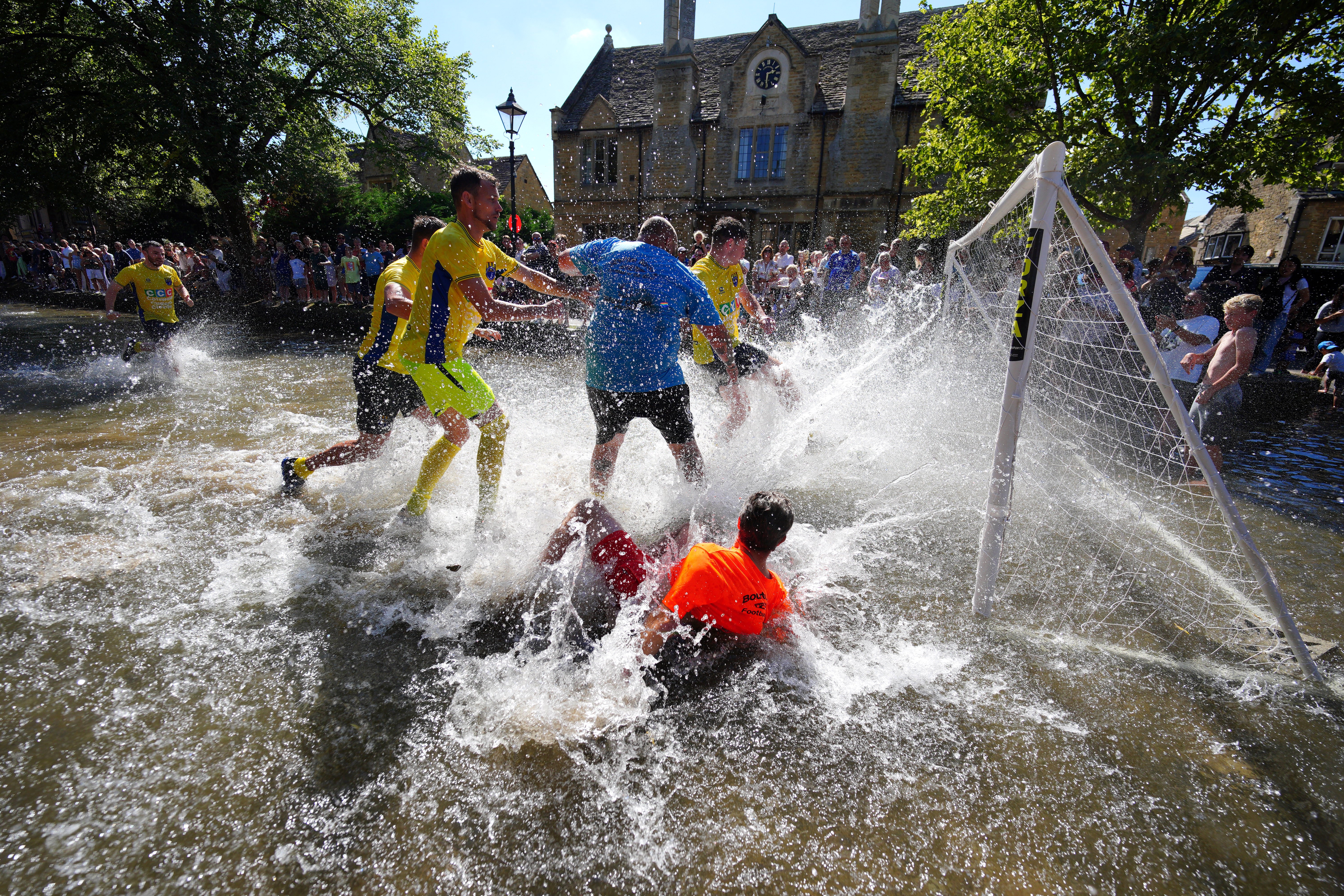 A soccer match held in ankle-deep water, splashing everywhere.