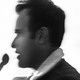 Blurry black-and-white photo of Vivek Ramaswamy speaking into a microphone