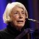 The poet Mary Oliver speaks at a podium.