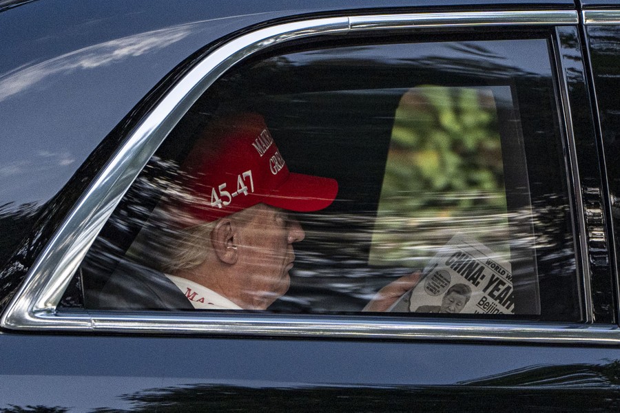 President Donald Trump, seated in the back seat of a car, reads an article in the <i>New York Post</i> about China's reaction to his tariffs.