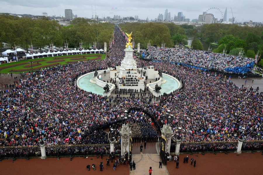 A large crowd gathers outside Buckingham Palace.