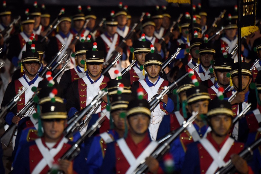 Actors dressed as Mexican soldiers march in a parade.