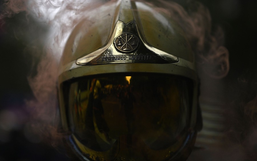 A close view of a firefighter's helmet partially surrounded by smoke