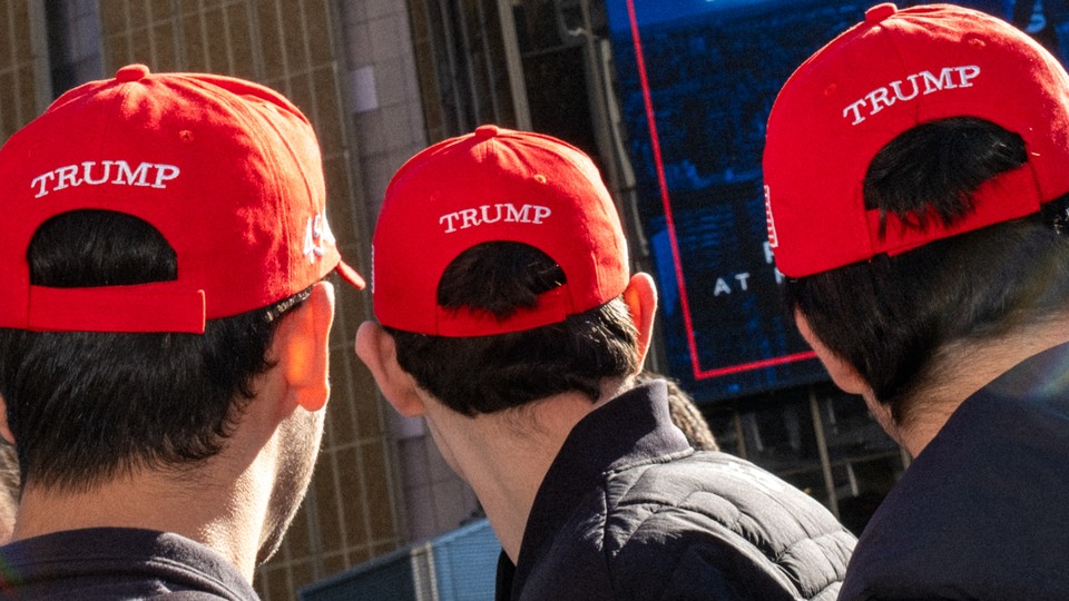 Three men wearing red Trump caps