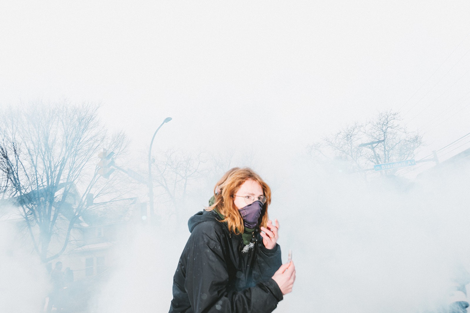 A woman with a mask is seen a cloud of smoke