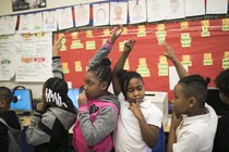 Kids in line holding up hands for quiet
