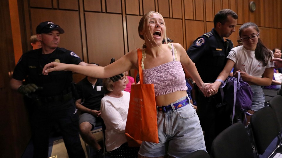 A protester interrupts the Kavanaugh hearings on Friday.