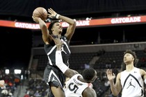 A basketball player in mid-air about to dunk