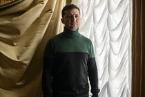 Ukraine's leader stands in front of a window.
