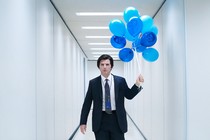 Mark (Adam Scott) carrying blue balloons in an office corridor on "Severance"