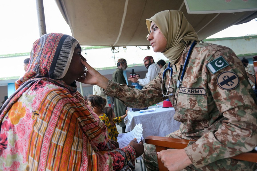 An army doctor checks a woman at a makeshift hospital.