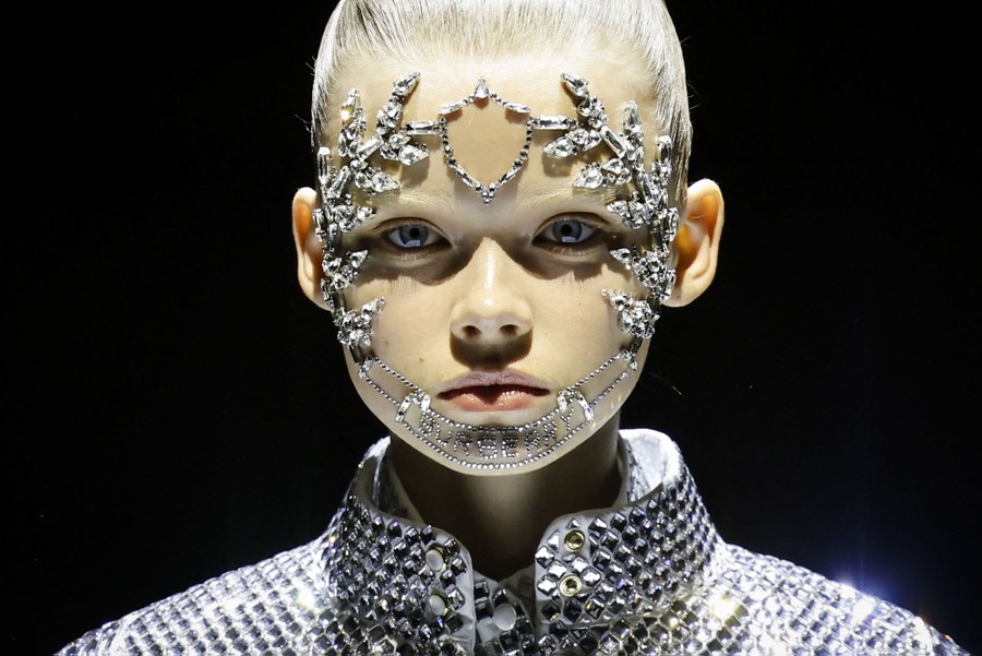 A model wears jeweled accessories on their face.