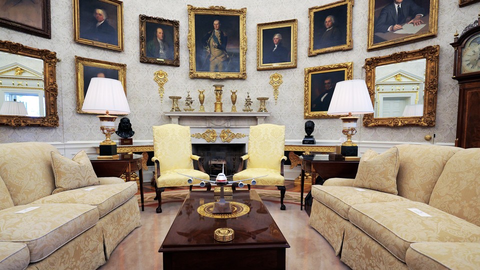 Empty Oval Office with portraits hanging on the walls