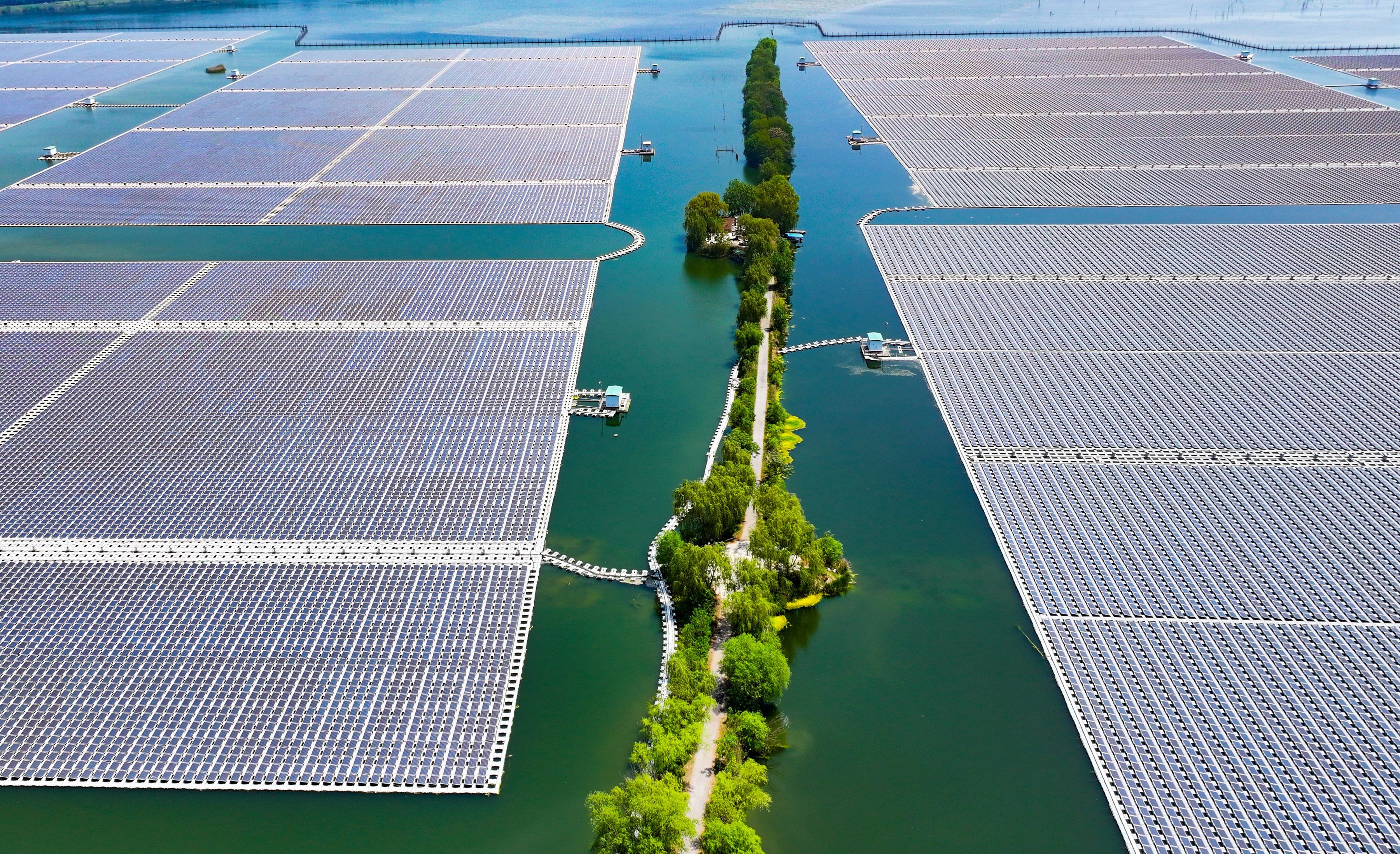 Large grids of solar panels float in a lake.