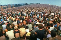 A wide-angle view of the huge crowd facing the distant stage during the Woodstock Music & Art Fair in August 1969