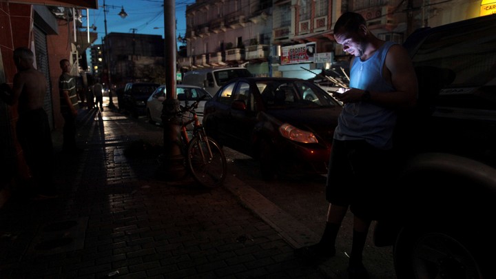 A man uses his phone during a blackout in San Juan, Puerto Rico.